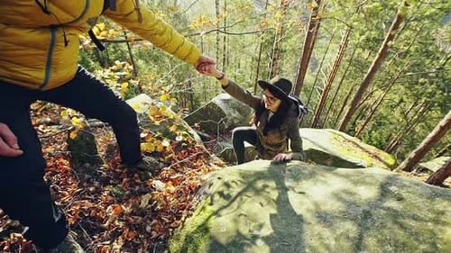 Young Guy Helping Girl Climb the Hill