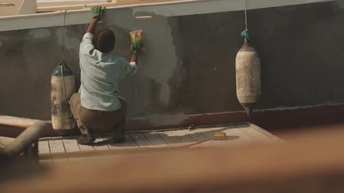 Female Worker Cleaning Boat Hull