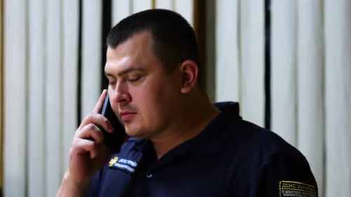 Man in Uniform Talking on Phone Indoors