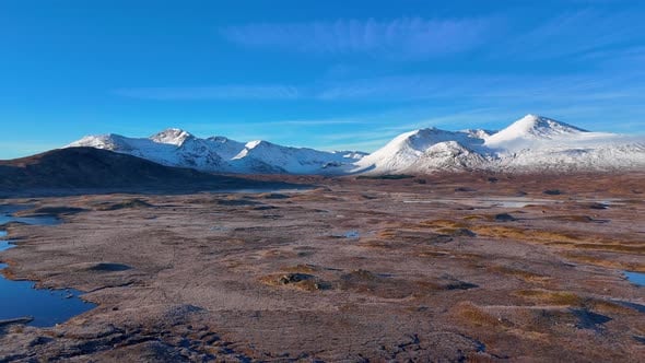 Aerial orbiting shot of the snowy mountains in Rannoch Moor in winter ...
