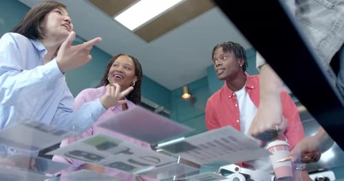 Discussing project ideas, diverse colleagues collaborating and smiling in modern office