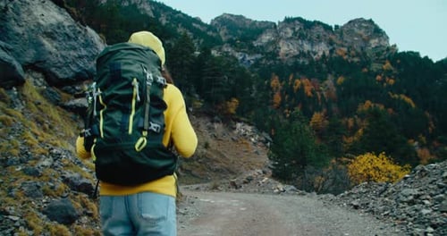 Handheld Shot Following Backpacker Tourist on Vacation Mountain Travel at Autumn