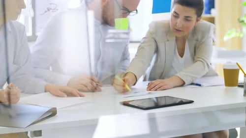 Office Colleagues Discussing Graphs and Data in Meeting