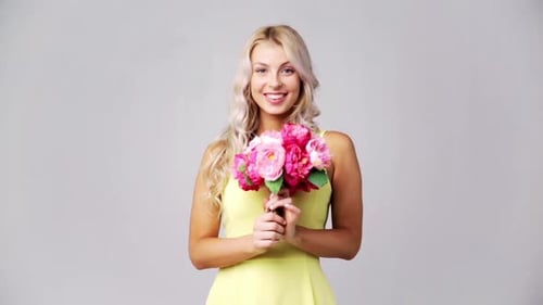 Holidays And People Concept - Happy Young Woman In Yellow Dress With Flowers