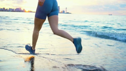Legs of a Runner Girl on the Beach Closeup View From the Back Slow Mo