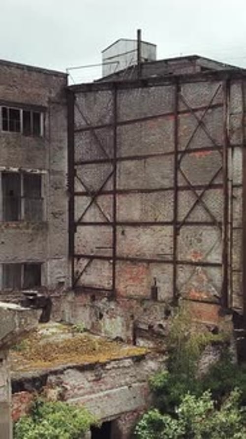 Ruins of an old factory. Old industrial building for demolition. Aerial view. Vertical video
