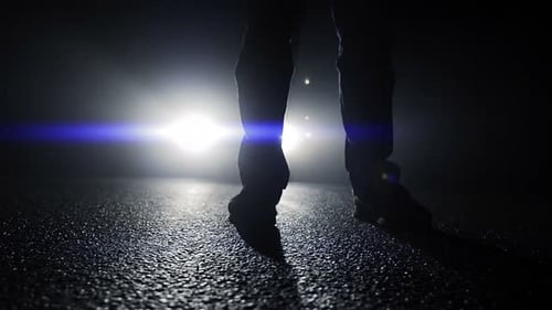Silhouetted Legs Stand On Dark Urban Road