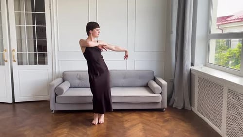 Woman in Slip Dress Dances Indoors with Natural Light