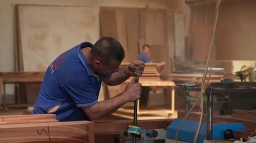 Man Operates Machine in Woodworking Shop