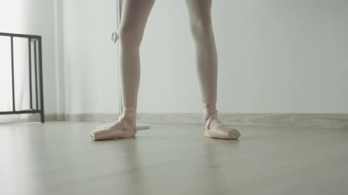 Dancer in pointe shoes showcases elegance and strength, with a serene studio enhancing focus.