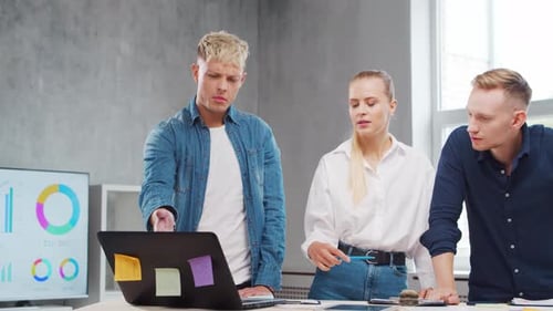 Team of Young Startupers is Working at the Table in the Office Discussing the Strategy and