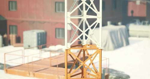 Torre de construcción en un sitio industrial cubierto de nieve bajo la luz del sol del invierno
