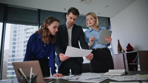 Business Team Reviewing Documents in Modern Office
