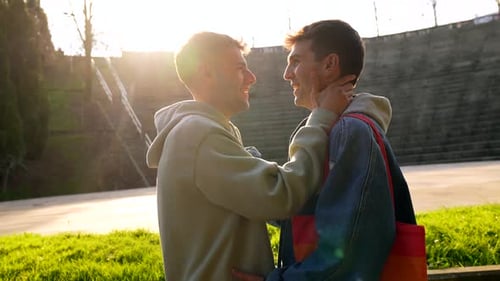 Young caucasian gay couple sharing intimate moments in a park
