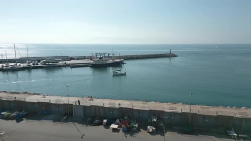 Aerial View of a Small Sail Boat Leaving Cambrils Port Slowly