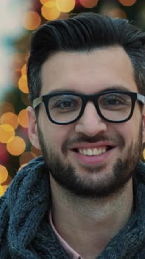 Un jeune homme contemplatif avec des lunettes entouré de belles lumières vives dans un espace chic