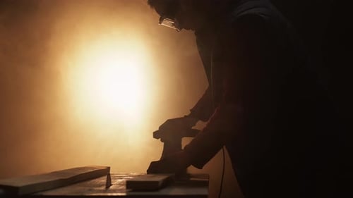 Man Sands Wood With Electric Sander
