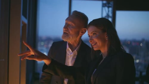 Two Late Workers Standing By Panoramic Window Business Center Closeup Smiling