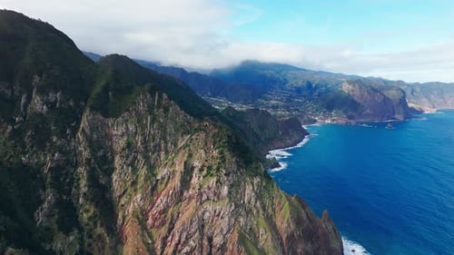Aerial view of mountains by ocean coastline, daytime