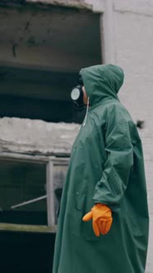 Figure in Hazmat Suit Stands Near Ruined Building