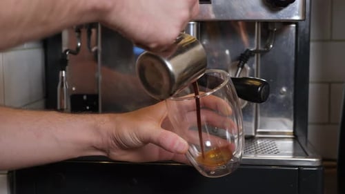Barista Pouring Espresso from Pitcher into Glass