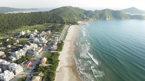 Cinematic aerial view with a drone of a beach with jungle mountains on the horizon of a brazilian co