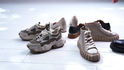 Modern footwear for different occasions on the floor put in a circle.