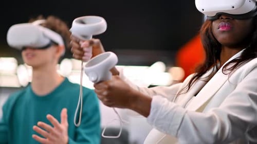 A black woman exploring virtual reality using VR glasses in an office, other people in VR glasses ne