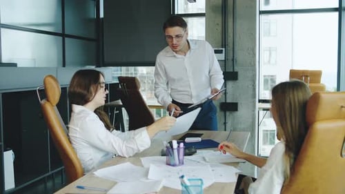 Team Collaborates in a Modern Office Setting on Project Ideas While Engaged in Discussion and