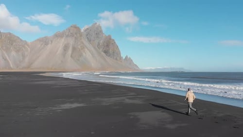 Man running along Stokksnes beach