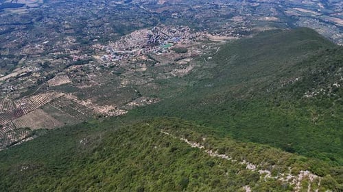 Camera panning over rural landscape revealing small village
