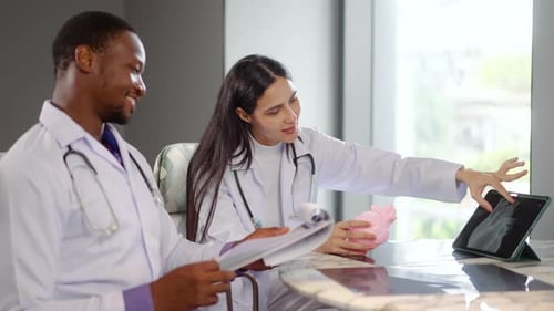 Doctors Reviewing Medical Data on Tablet in Office