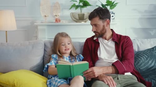 Father and Daughter Reading a Book Together at Home