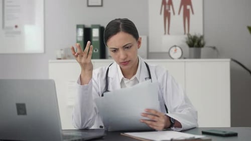 Female Doctor Reviewing Medical Documents in Office