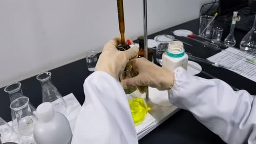 Scientist Titrating Yellow Solution in Laboratory