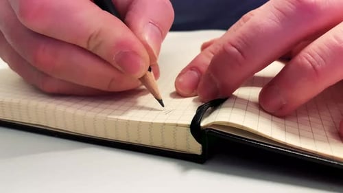 Hand is writing on the paper, education concept close up