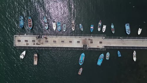 Eine Luftaufnahme eines Docks, an dem Fischerboote vor Anker liegen, schafft eine malerische Szene, die einfängt