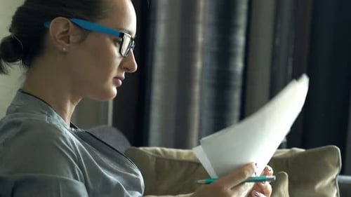 Woman reviews documents and types on her laptop