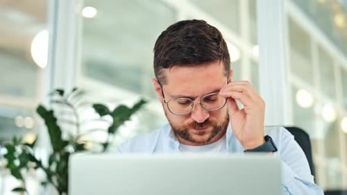 Stressed Male Worker Experiencing Headache in Office