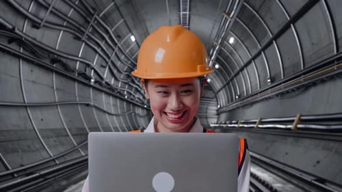 Close Up Of Asian Female Engineer Working On A Laptop In Subway Tunnel