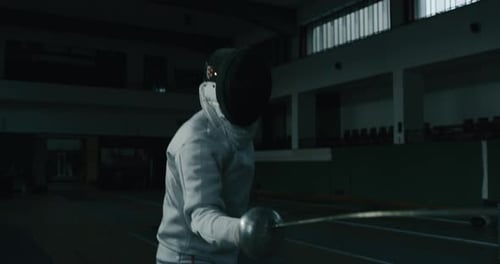 Cinematic slow motion shot of two professional young people is practising assaults of fencing with