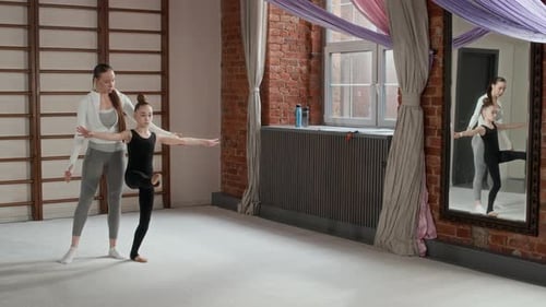 Young girl learning gymnastics from instructor