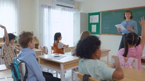 Adorable student learn with teacher in classroom at elementary school.