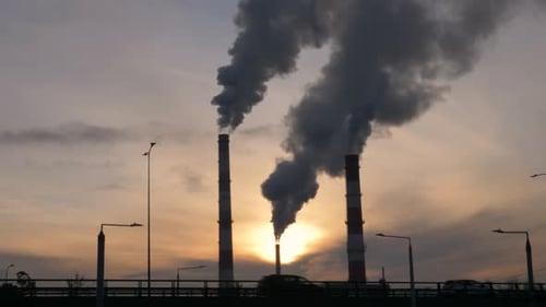 Slow motion shot of urban in the golden hour. Factory chimneys in the background.
