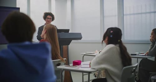 Confident Female Instructor Teaches Coding to Attentive Students Pointing Lines Code on Display