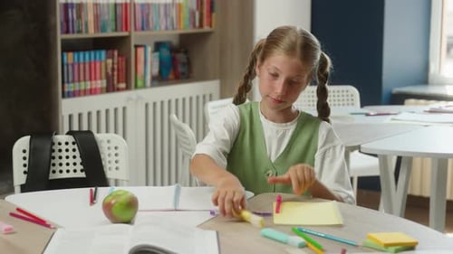 Girl Studying in Classroom with Books and Apple