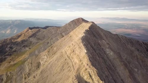 Dramático paisaje rodea el monte Nebo Utah bajo la luz del sol de la hora dorada - AERIAL TRUCKING PAN TILT