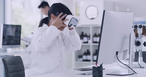 Scientist using virtual reality goggles to examine medical research experiment in 3D