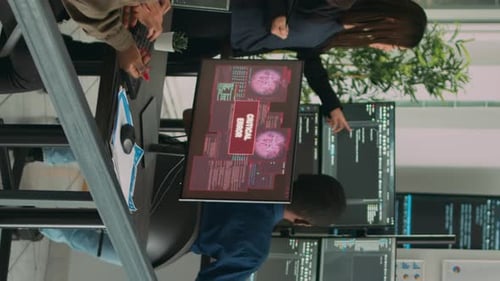 Three Colleagues Analyze Computer Code in an Office