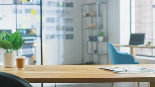 Bureau en bois dans le Creative Bright Office. En arrière-plan, jeune homme professionnel travaillant sur Comp